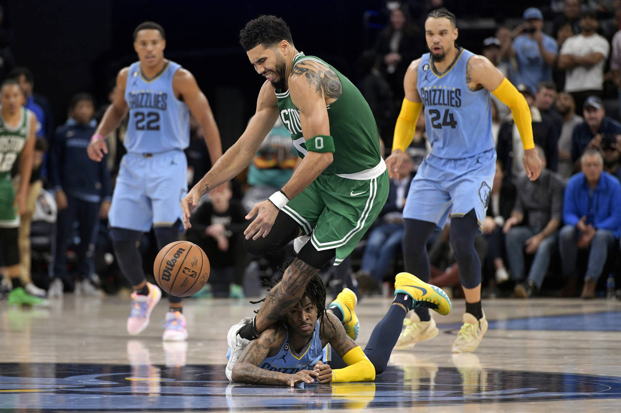 Memphis Grizzlies guard Ja Morant, below, collides with Boston Celtics forward Jayson Tatum (0) in ...