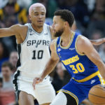 
              Golden State Warriors guard Stephen Curry (30) moves the ball while defended by San Antonio Spurs forward Jeremy Sochan (10) during the first half of an NBA basketball game in San Francisco, Monday, Nov. 14, 2022. (AP Photo/Godofredo A. Vásquez)
            