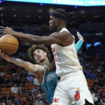 
              Charlotte Hornets guard LaMelo Ball (1) knocks the ball off the hand of Miami Heat forward Jimmy Butler (22) during the first half of an NBA basketball game Saturday, Nov. 12, 2022, in Miami. (AP Photo/Marta Lavandier)
            