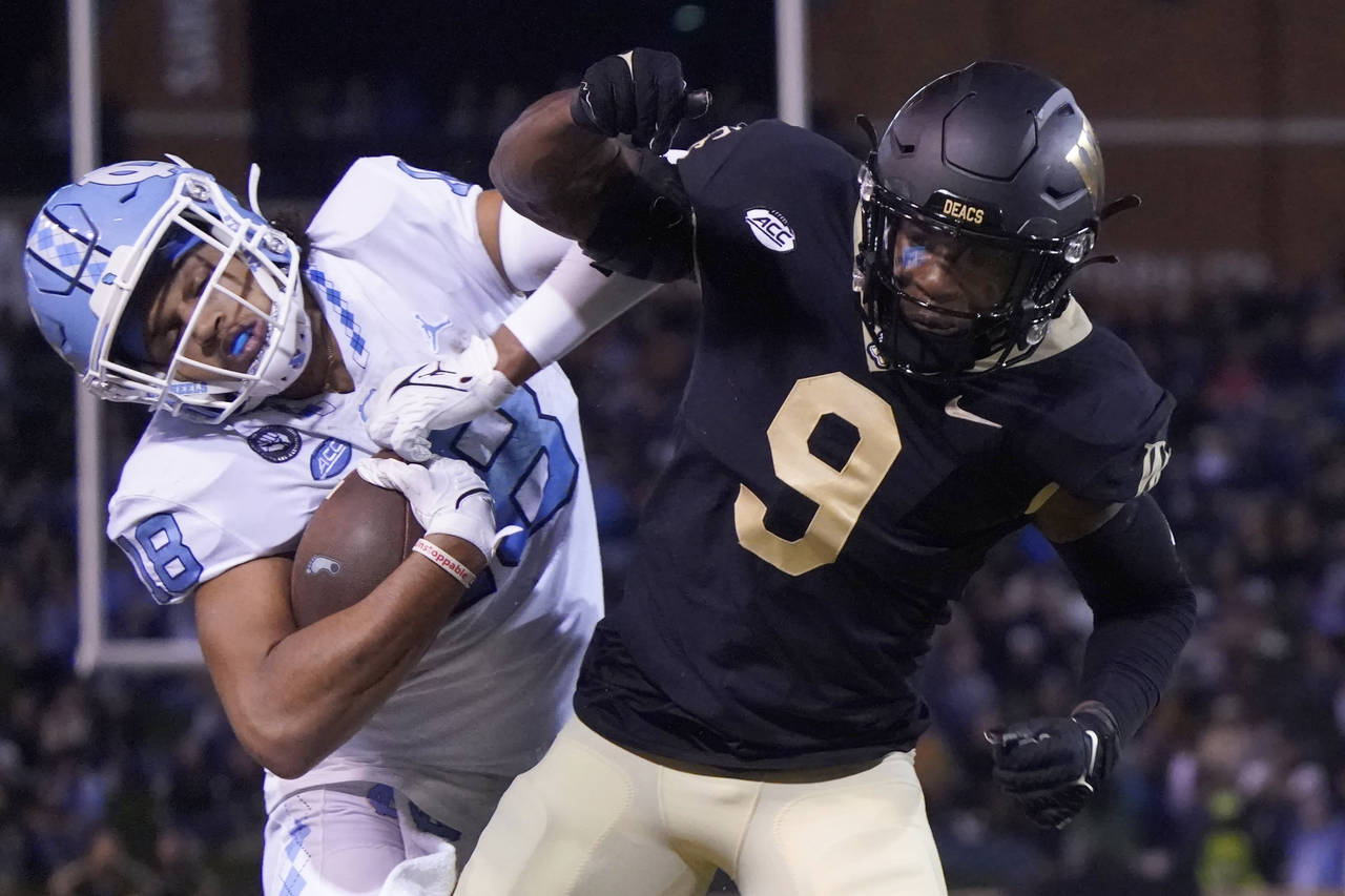 North Carolina tight end Bryson Nesbit (18) is knocked out of bounds by Wake Forest defensive back ...