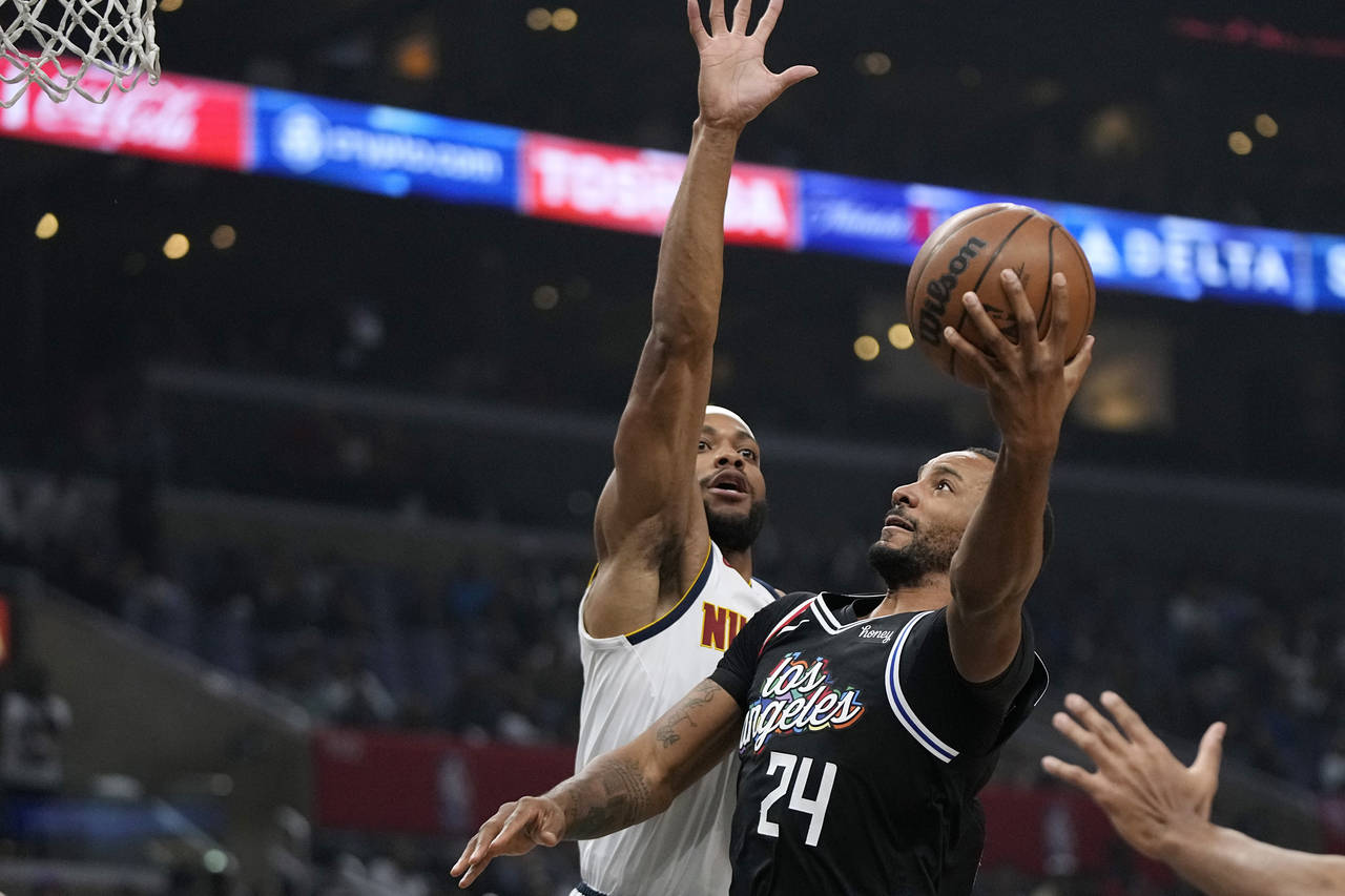 Los Angeles Clippers forward Norman Powell, right, shoots as Denver Nuggets forward Bruce Brown def...