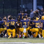 
              Dearborn Fordson High School receiver Hassan Shinawah leads the team in prayer before its game against Dearborn High School, Friday, Oct. 14, 2022 in Dearborn, Mich. It was the only time this season that the team held its prayer outside the locker room and only because Senior Day festivities and pregame messages from coaches ran long. (AP Photo/Carlos Osorio)
            