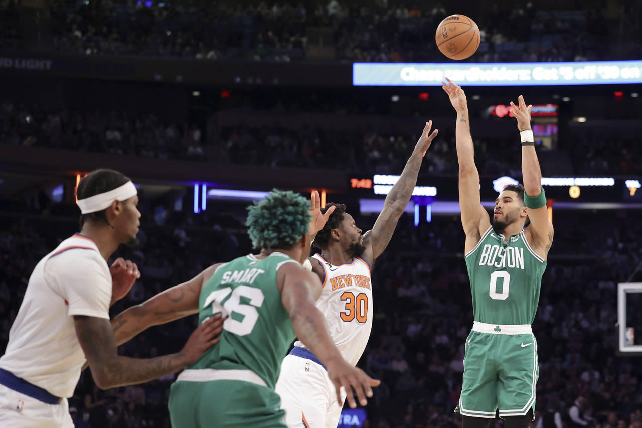 Boston Celtics forward Jayson Tatum (0) shoots as New York Knicks forward Julius Randle (30) defend...