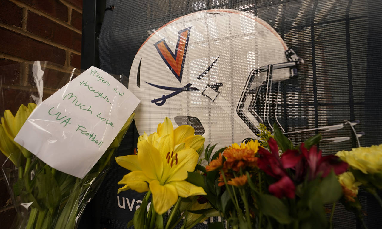 Memorial flowers and notes line walkway at Scott Stadium after three football players were killed i...