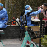 
              A woman lifts her mask to get swabbed for COVID test in Beijing, Sunday, Nov. 6, 2022. (AP Photo/Ng Han Guan)
            