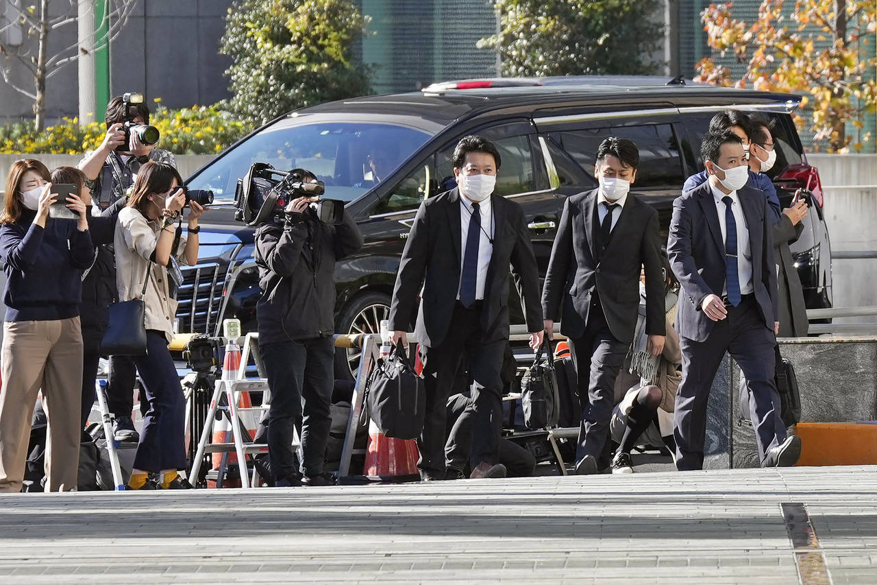 Investigators enter the headquarters of major advertising company Dentsu in Tokyo Friday, Nov. 25, ...
