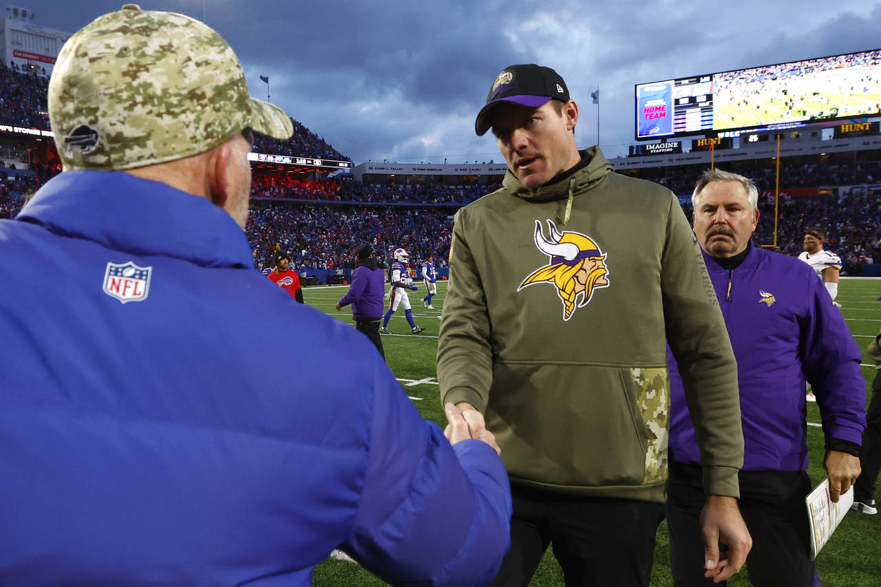 Minnesota Vikings head coach Kevin O'Connell, center, shakes hands with Buffalo Bills head coach Se...