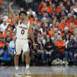 
              Virginia's Kihei Clark (0) celebrates after making a 3-point shot against Illinois during the first half of an NCAA college basketball game Sunday, Nov. 20, 2022, in Las Vegas. (AP Photo/John Locher)
            