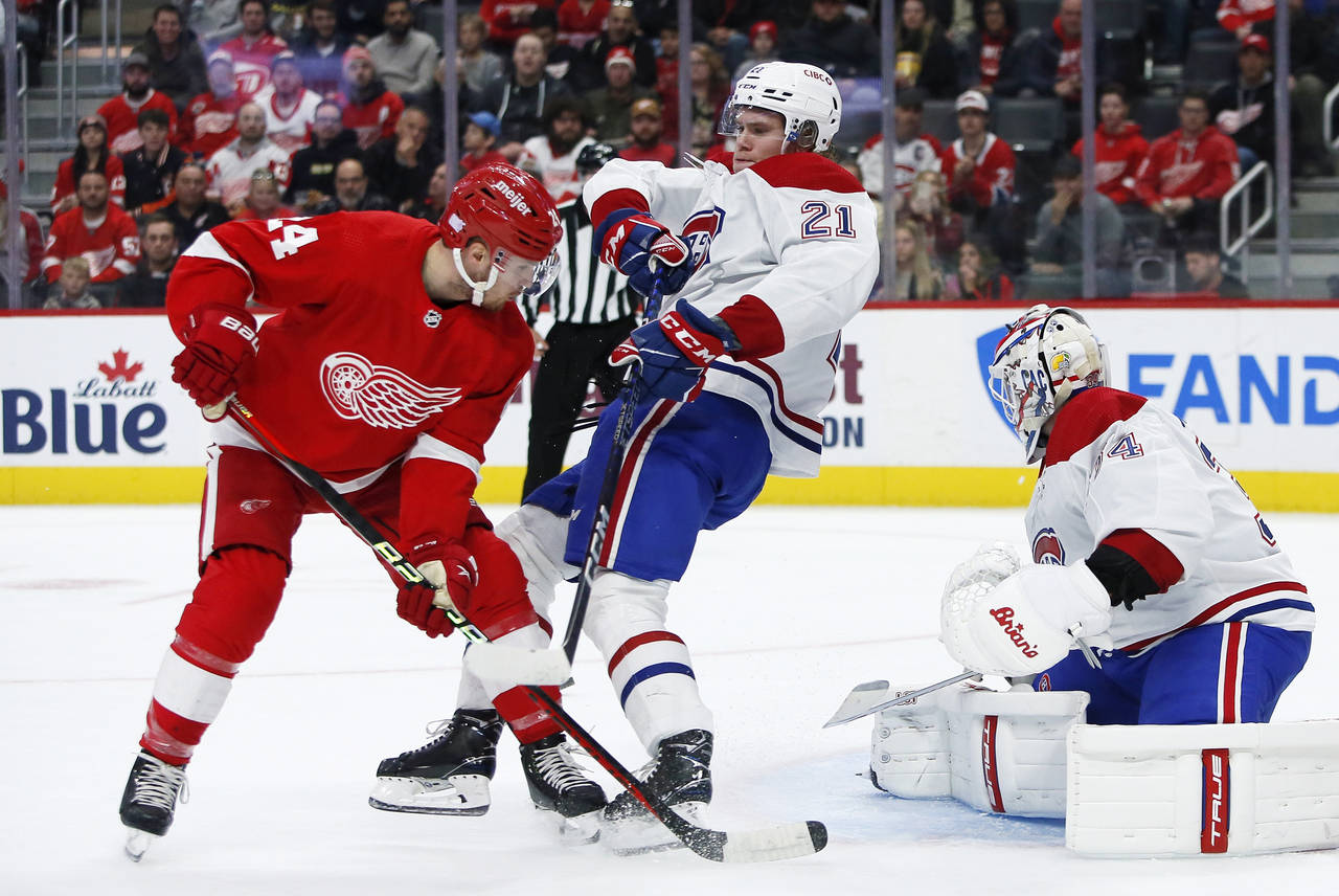 Detroit Red Wings center Pius Suter (24) collides with Montreal Canadiens defenseman Kaiden Guhle (...