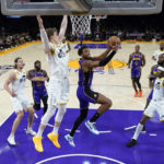 
              Los Angeles Lakers forward Troy Brown Jr., center, drives to the basket as Utah Jazz forward Lauri Markkanen (23) defends during the first half of an NBA basketball game Friday, Nov. 4, 2022, in Los Angeles. (AP Photo/Marcio Jose Sanchez)
            