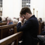 
              A person prays at a service at St. Paul's Memorial Church in response to the shootings that happened on the University of Virginia campus the night before in Charlottesville, Va., Monday, Nov. 14, 2022. (Mike Kropf/The Daily Progress via AP)
            