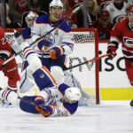 
              Edmonton Oilers center Klim Kostin (37) hits the ice as he plays the puck against Carolina Hurricanes right wing Stefan Noesen (23) and center Paul Stastny (26) while Edmonton defenseman Darnell Nurse (25) watches during the first period of an NHL hockey game Thursday, Nov. 10, 2022, in Raleigh, N.C. (AP Photo/Chris Seward)
            