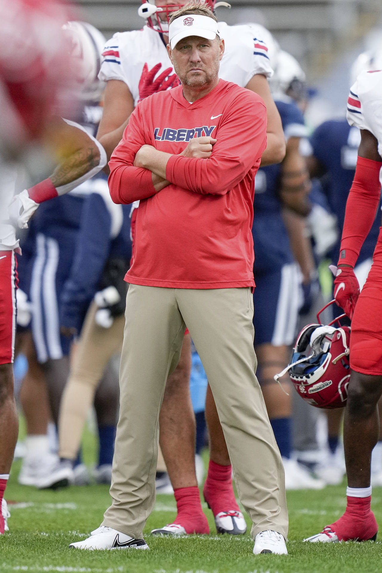 Liberty head coach Hugh Freeze watches as players warm up prior to an NCAA college football game ag...