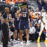 
              Virginia guard Ryan Dunn (13) celebrates after a play against Baylor during the second half of an NCAA college basketball game Friday, Nov. 18, 2022, in Las Vegas. (AP Photo/Chase Stevens)
            