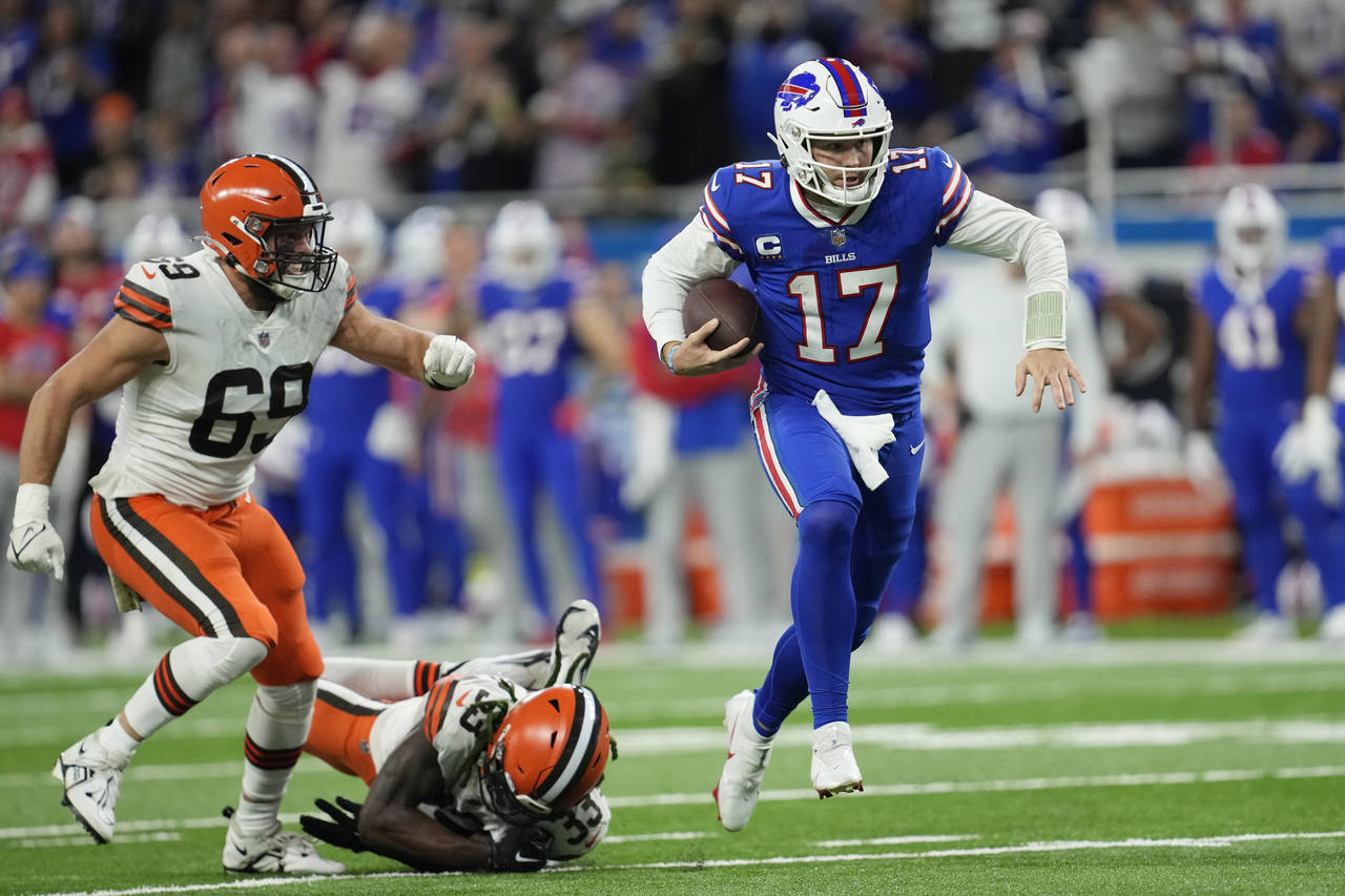 Buffalo Bills quarterback Josh Allen (17) scrambles past Cleveland Browns defensive end Chase Winov...