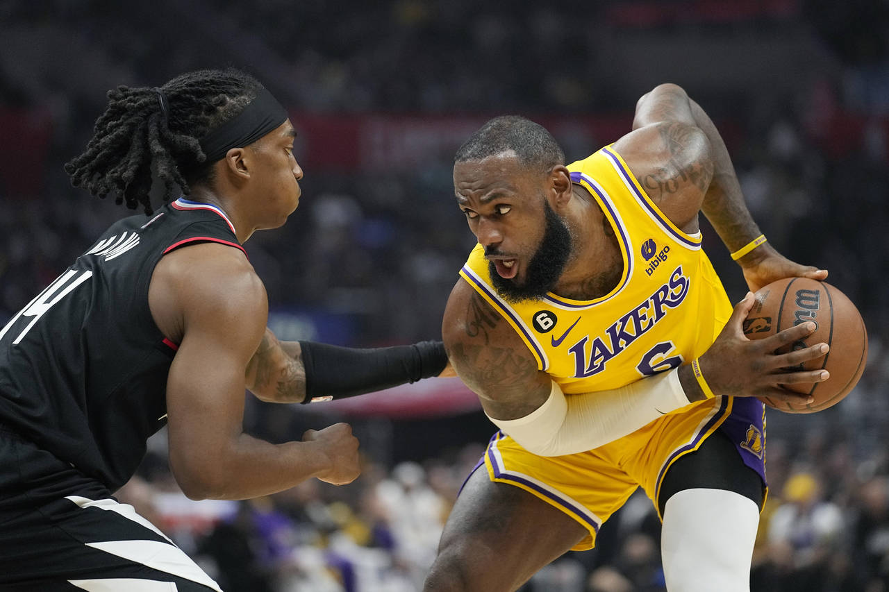 Los Angeles Lakers forward LeBron James, right, tries to get past Los Angeles Clippers guard Teranc...