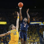 
              Virginia guard Reece Beekman (2) shoots over Michigan guard Joey Baker (15) in the first half of an NCAA college basketball game in Ann Arbor, Mich., Tuesday, Nov. 29, 2022. (AP Photo/Paul Sancya)
            