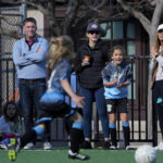 
              Ziza Polak, second from right, cheers on her brother Ekko, foreground, during a soccer match in San Francisco, Saturday, Nov. 12, 2022. (AP Photo/Godofredo A. Vásquez)
            