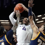 
              Kansas State guard Tykei Greene (4) shoots between Kansas City guards RayQuawndis Mitchell, left and Tyler Andrews, right, during the first half of an NCAA college basketball game Thursday, Nov. 17, 2022, in Manhattan, Kan. (AP Photo/Charlie Riedel)
            