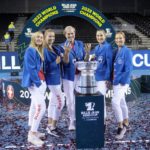 
              Switzerland's players Jil Teichmann, Simona Waltert, Belinda Bencic and Viktorija Golubic,, from left, pose with Switzerland team captain Heinz Guenthardt, in the center, and their trophy after defeating Australia to win the Billie Jean King Cup tennis finals, at the Emirates Arena in Glasgow, Scotland, Sunday, Nov. 13, 2022. (AP Photo/Kin Cheung)
            