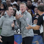 
              Golden State Warriors coach Steve Kerr, middle, reacts after an official's call, next to assistant Kenny Atkinson, left, during the first half of the team's NBA basketball game against the Cleveland Cavaliers in San Francisco, Friday, Nov. 11, 2022. (AP Photo/Jeff Chiu)
            