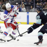 
              New York Rangers Mika Zibanejad (93) passes the puck against Seattle Kraken Vince Dunn (29) during the first period of an NHL hockey game, Thursday, Nov. 17, 2022, in Seattle. (AP Photo/John Froschauer)
            