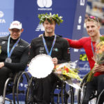 
              From left, men's wheelchair division second place finisher Daniel Romanchuk, winner Marcel Hug, of Switzerland, and third place finisher Jetze Plat, of the Netherlands, pose during a ceremony at the finish line of the New York City Marathon, Sunday, Nov. 6, 2022, in New York. (AP Photo/Jason DeCrow)
            