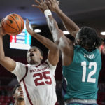 
              Oklahoma guard Grant Sherfield (25) shoots as UNC Wilmington center Victor Enoh (12) defends in the second half of an NCAA college basketball game Tuesday, Nov. 15, 2022, in Norman, Okla. (AP Photo/Sue Ogrocki)
            