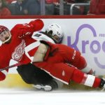
              Arizona Coyotes defenseman Jakob Chychrun, right, is crushed against the boards by Detroit Red Wings defenseman Filip Hronek, left, during the second period of an NHL hockey game Friday, Nov. 25, 2022, in Detroit. (AP Photo/Duane Burleson)
            