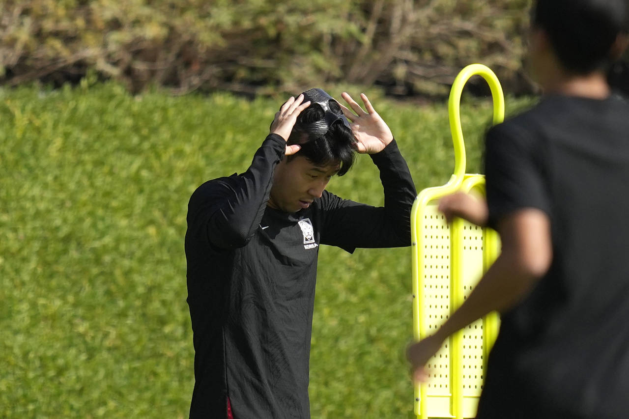South Korea's Son Heung-min adjusts a mask during the South Korea's official training on the eve of...