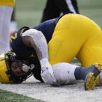 
              Michigan running back Blake Corum (2) grabs at his knee after being injured on a run against Illinois in the first half of an NCAA college football game in Ann Arbor, Mich., Saturday, Nov. 19, 2022. (AP Photo/Paul Sancya)
            