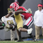 
              Georgia Tech wide receiver Malik Rutherford (12) is brought down by Georgia defensive back Tykee Smith (23) after a catch during the first half of an NCAA college football game Saturday, Nov. 26, 2022 in Athens, Ga. (AP Photo/John Bazemore)
            