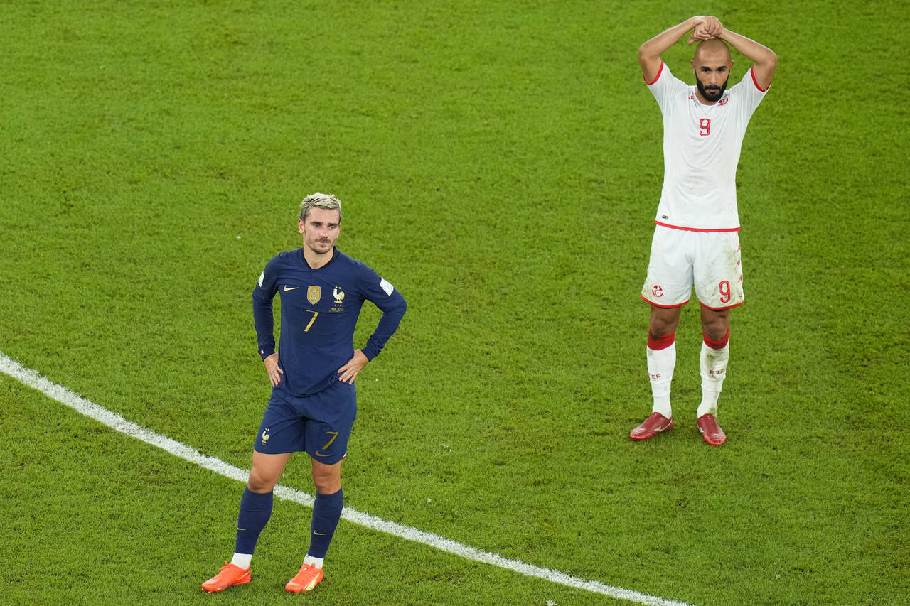 France's Antoine Griezmann, left, and Tunisia's Issam Jebali wait as Referee Matthew Conger, of New...