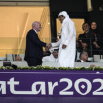 
              FILE - Emir of Qatar Tamim bin Hamad Al Thani, right, shakes hands with FIFA President Giovanni Infantino, left, prior the World Cup, group A soccer match between Qatar and Ecuador at the Al Bayt Stadium in Al Khor, Sunday, Nov. 20, 2022. Qatar became the first host nation in World Cup history to lose the opening match, and then only the second host to be eliminated from the group stage. South Africa in 2010 was the first host nation to be eliminated in group stage but still had a chance to advance in its third and final group match. (AP Photo/Natacha Pisarenko, File)
            