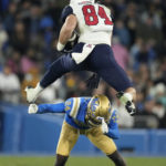 
              Arizona tight end Tanner McLachlan, top, jumps over UCLA defensive back Jaylin Davies during the first half of an NCAA college football game Saturday, Nov. 12, 2022, in Pasadena, Calif. (AP Photo/Mark J. Terrill)
            