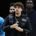 
              Injured Charlotte Hornets guard LaMelo Ball watches from the bench during the first overtime of an NBA basketball game against the Cleveland Cavaliers, Friday, Nov. 18, 2022, in Cleveland. (AP Photo/Ron Schwane)
            