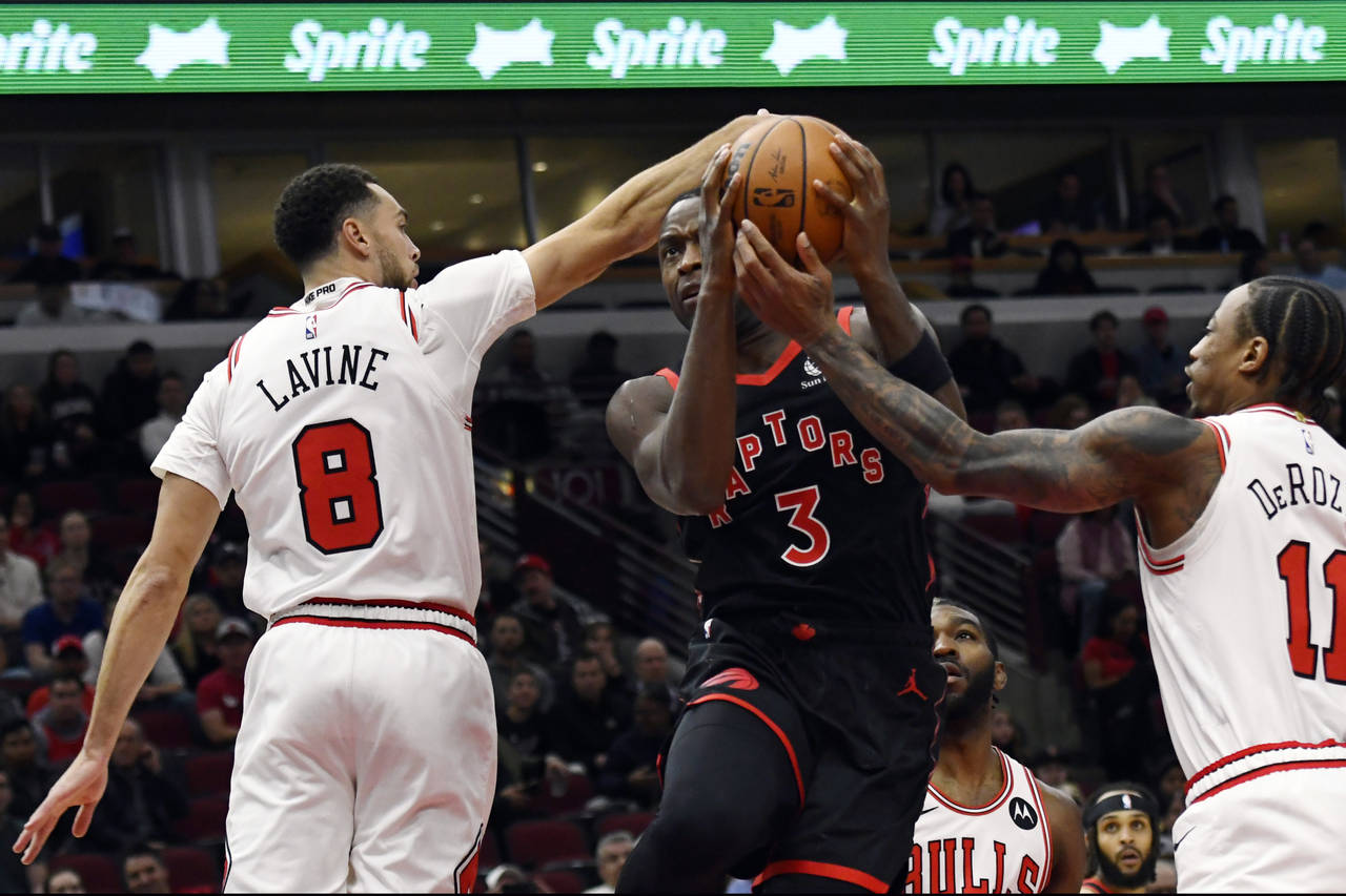 Toronto Raptors' O.G. Anunoby (3) goes up for a shot against Chicago Bulls' DeMar DeRozan (11) and ...