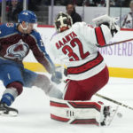 
              Carolina Hurricanes goaltender Antti Raanta, right, clears the puck next to Colorado Avalanche right wing Logan O'Connor during the first period of an NHL hockey game Saturday, Nov. 12, 2022, in Denver. (AP Photo/David Zalubowski)
            