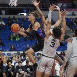 
              Florida guard Riley Kugel shoots in front of Xavier guard Colby Jones (3), guard Desmond Claude and forward Jerome Hunter (2) during the first half of an NCAA college basketball game in the Phil Knight Legacy tournament in Portland, Ore., Thursday, Nov. 24, 2022. (AP Photo/Craig Mitchelldyer)
            