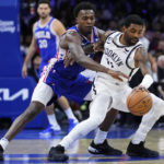
              Philadelphia 76ers' Paul Reed, left, and Brooklyn Nets' Kyrie Irving battle for the ball during the first half of an NBA basketball game, Tuesday, Nov. 22, 2022, in Philadelphia. (AP Photo/Matt Slocum)
            