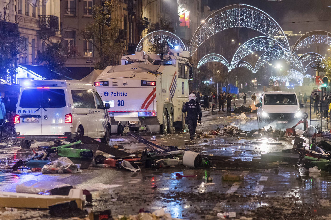 Police cars drive through a main boulevard in Brussels, Sunday, Nov. 27, 2022, as violence broke ou...