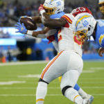 
              Los Angeles Chargers running back Austin Ekeler, left, scores a touchdown as he is face masked by Kansas City Chiefs linebacker Nick Bolton during the first half of an NFL football game Sunday, Nov. 20, 2022, in Inglewood, Calif. (AP Photo/Jae C. Hong)
            