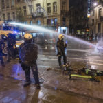 
              Riot police officers stand along a main boulevard in Brussels, Sunday, Nov. 27, 2022, as violence broke out during and after Morocco's 2-0 win over Belgium at the World Cup. Police had to seal off parts of the center of Brussels and moved in with water cannons and tear gas to disperse crowds. (AP Photo/Geert Vanden Wijngaert)
            
