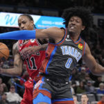 
              Chicago Bulls forward DeMar DeRozan (11) and Oklahoma City Thunder forward Jalen Williams (8) reach for the ball in the first half of an NBA basketball game Friday, Nov. 25, 2022, in Oklahoma City. (AP Photo/Sue Ogrocki)
            