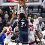 
              Dallas Mavericks forward Christian Wood (35) attempts a dunk as Toronto Raptors forwards Thaddeus Young (21) and Chris Boucher (25) defend during the first half of an NBA basketball game Friday, Nov. 4, 2022, in Dallas. (AP Photo/Brandon Wade)
            