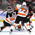 
              Philadelphia Flyers goaltender Carter Hart (79) makes a save as defenseman Tony DeAngelo (77) tries to keep Ottawa Senators left wing Brady Tkachuk (7) from reaching the puck during the second period of an NHL hockey game, Saturday, Nov. 5, 2022 in Ottawa, Ontario. (Justin Tang/The Canadian Press via AP)
            