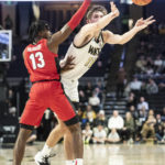 
              Wake Forest forward Andrew Carr (11) passes around Georgia guard Mardrez McBride (13) in the first half of an NCAA college basketball game Friday, Nov. 11, 2022, in Winston-Salem, N.C. (Allison Lee Isley/The Winston-Salem Journal via AP)
            
