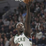 
              Milwaukee Bucks guard Jrue Holiday (21) attempts to shoot during the first half of an NBA basketball game against the Minnesota Timberwolves, Friday, Nov. 4, 2022, in Minneapolis. (AP Photo/Abbie Parr)
            