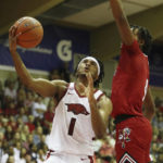 
              Arkansas guard Ricky Council IV (1) goes to the basket over Louisville forward Roosevelt Wheeler during the first half of an NCAA college basketball game, Monday, Nov. 21, 2022, in Lahaina, Hawaii. (AP Photo/Marco Garcia)
            