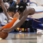 
              New York Knicks guard Jalen Brunson, left, and Oklahoma City Thunder forward Luguentz Dort, right, dive for a loose ball in the first half of an NBA basketball game, Monday, Nov. 21, 2022, in Oklahoma City. (AP Photo/Sue Ogrocki)
            